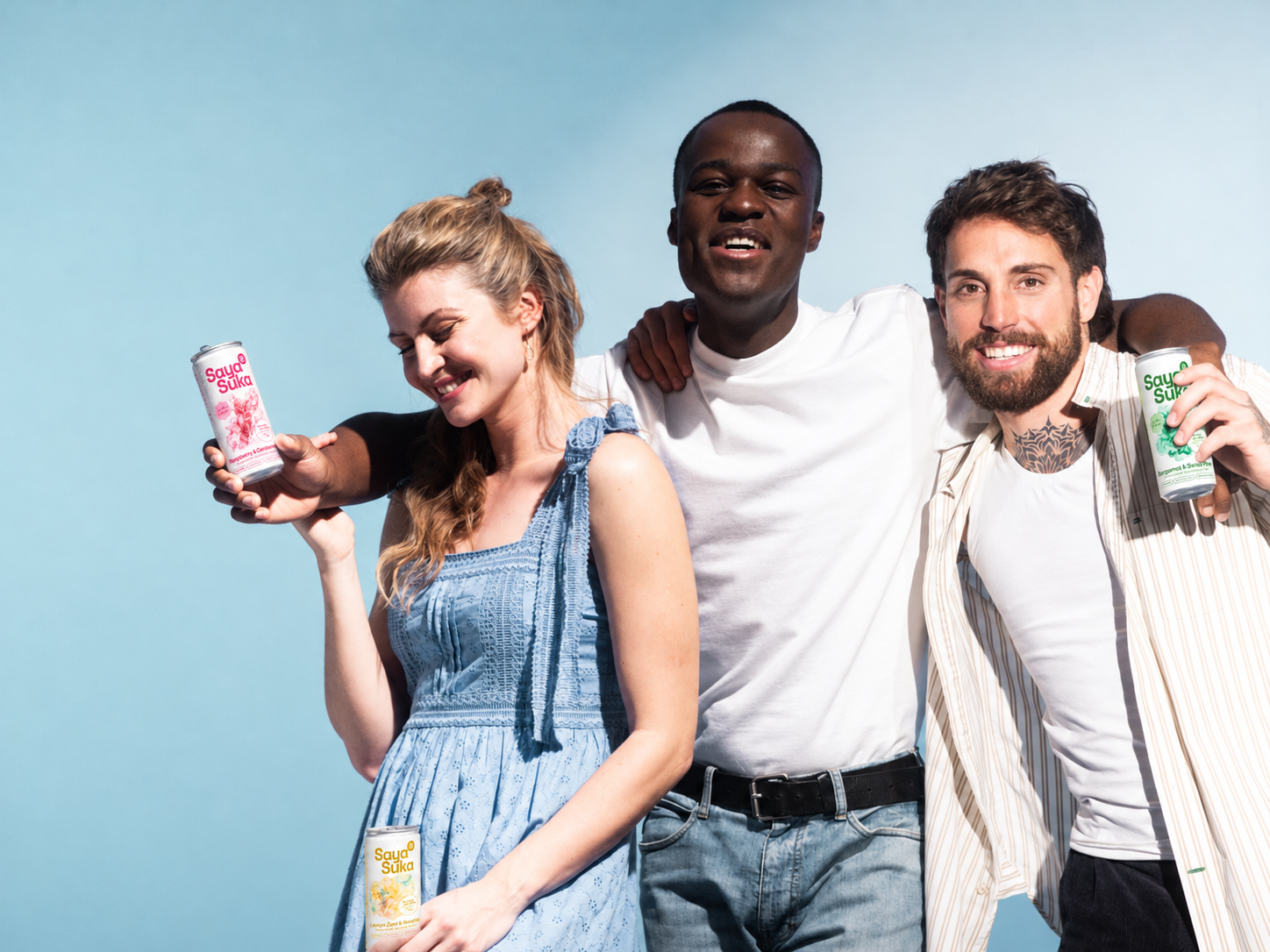 Three friends sharing Saya Suka functional sparkling water in Bergamot & Swiss Pine, Raspberry & Cardamom and Lemon Zest & Rosehip